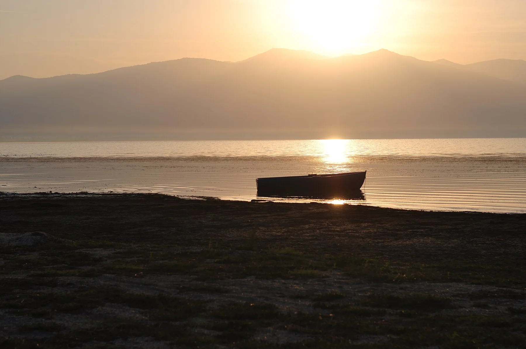 A boat at sunrise on Lake Prespa in Oteševo